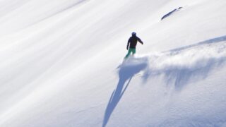 A person snowboarding across a mountainside